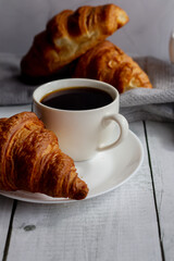A cup of coffee and croissants. on white wooden. breakfast. Morning