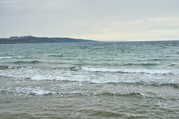 Wavy winter sea and a lantern on the horizon