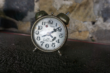 old and antique watch on the table with stone wall background