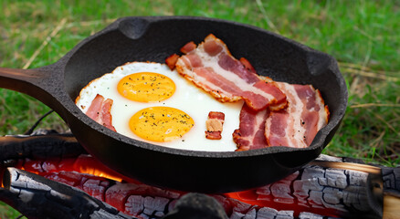 eggs and bacon cooking with oil in the field during a walk outdoors in high resolution