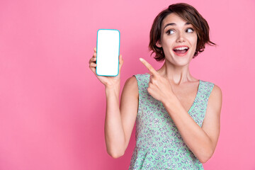 Photo of young promoter woman direct finger looking interested phone touch screen offer scanning qr code isolated on pink color background