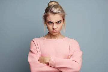 Fotobehang Portrait of angry dissatisfied European young female frowning her face, holding fists in front of her, ready to fight or defend herself. aggressive, emotional female, feeling insulted © Ameer