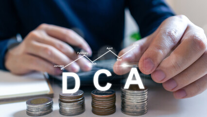 Dca or Dollar Cost Averaging.Man hand putting coins on stack and calculator on table, Saving money...