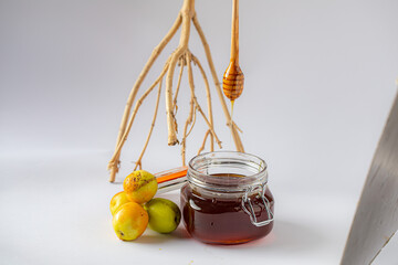 Honey dripping from honey dipper in wooden bowl. Close-up. Healthy organic Thick honey dipping from the wooden honey spoon, closeup.
