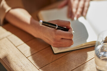 Hand of businesswoman writing notes