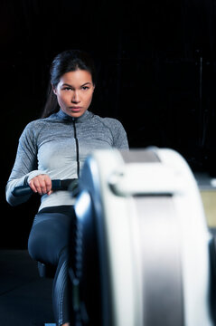 Mid adult woman using rowing machine