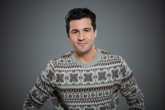 Portrait of young man wearing patterned sweater.