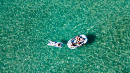 Aerial drone view of children go for a drive on an inflatable boat under supervision of single...