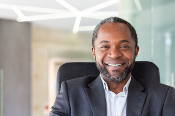 Close up portrait of successful successful businessman, man looking joyfully at camera sitting at...