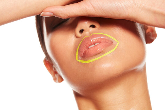 Young woman with yellow circle around her mouth shielding her eyes