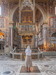 Religieuse de dos priant à l'intérieur de la Basilique Saint-Jean-de-Latran à Rome, Italie.
