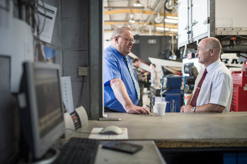 Businessmen talking in repair shop