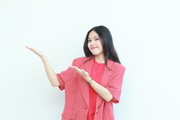 portrait of beautiful asian woman wearing red outfit pointing to the side for copy space