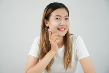 Beautiful Asian woman smile use cream for good skin. face of a healthy woman apply cream and makeup. Advertisement for skin cream, anti-wrinkle, baby face, whitening, moisturizer, tighten pores serum.