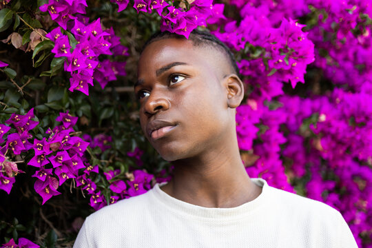 Confident black teenage boy near blooming flowers - Powered by Adobe