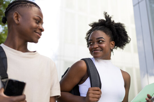 Cheerful black teenage couple admiring each other