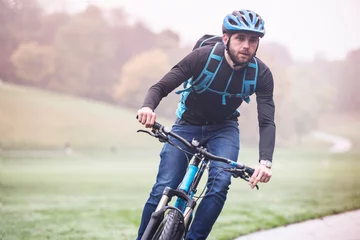 Foto op Plexiglas Man commuting on bicycle through park © Image Source