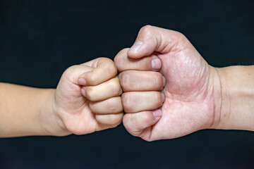 A Fist Of A Child And An Adult Male,Competition And Victory Concept