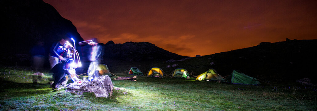 Long exposure of camp by mountains at night