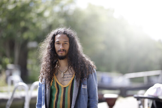Young man with long hair in park