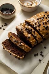 Chocolate loaf pound cake slices with coffee icing and chocolate chips, top view.