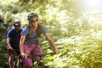 Couple mountain biking in forest