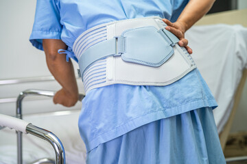 Asian lady patient use walker in hospital to support walking.