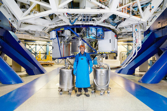 Scientist with gas tanks under telescope at Paranal Observatory