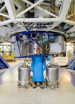 Scientist with gas tanks under telescope at Paranal Observatory
