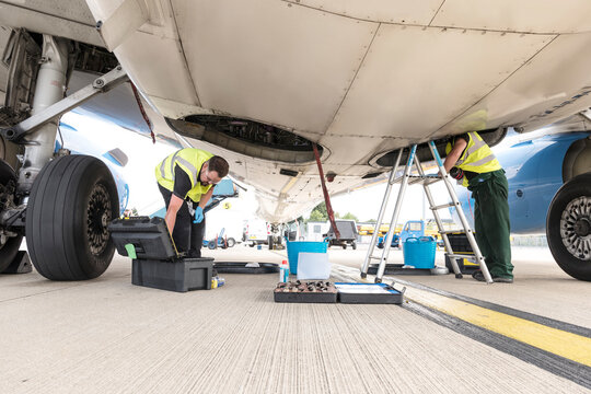 Men working underneath airplane