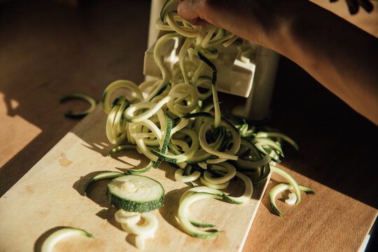 Woman's hand making zucchini noodles