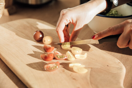 Woman's hands chopping tomatoes