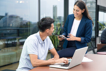 Colleagues using laptop and digital tablet on balcony