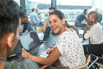Colleagues using laptops during meeting