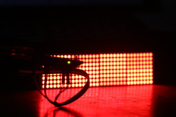 Micro controller is controlling an electronic component on the background. LED dot matrix display board illuminating red color light