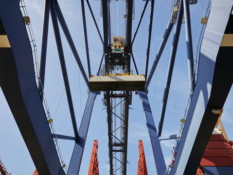 Crane unloading cargo container from ship