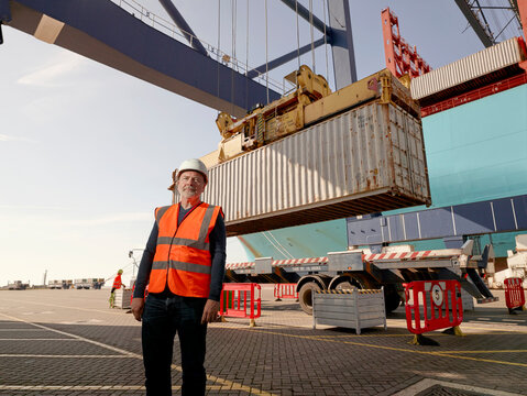 Dock worker by cargo container and truck at Port of Felixstowe, England