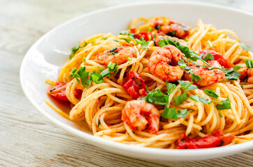 Piatto di deliziosi spaghetti con pomodoro, prezzemolo e gamberetti, cibo italiano 