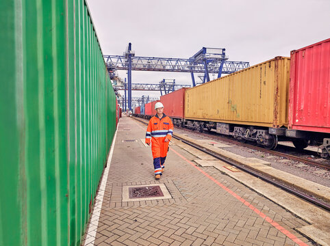 Dock worker walking by cargo freight train