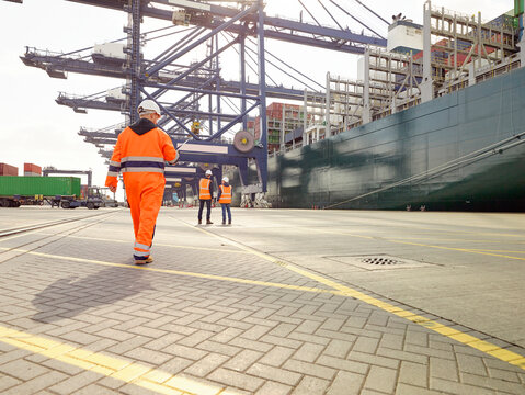 Dock workers beside cargo ship at Port of Felixstowe, England