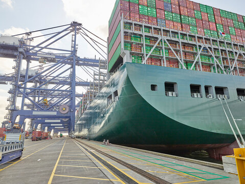Huge cargo ship with full load waiting to be emptied at dock port