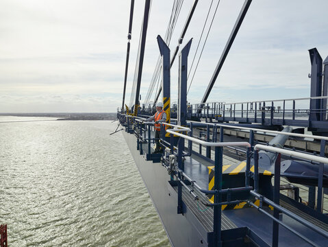 Dock worker looking at view from crane railing