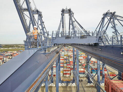Elevated view of dock worker on cargo crane platform, Felixstowe, England