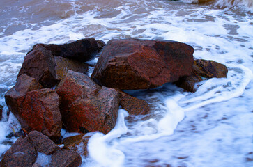 coastal stones in the surf, bubbling water close-up
