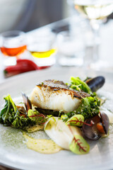 Cod fillet with cauliflower cream, asparagus, clam-wine sauce and mussles. Delicious seafood fish closeup served on a table for lunch in modern cuisine gourmet restaurant - 633092130