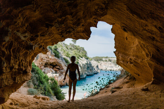 Girl exploring a cave at Calo des Moro in Mallorca