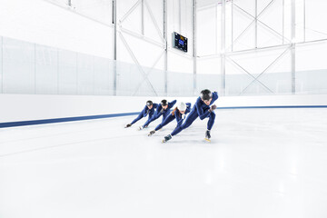 A team of speed skaters practicing at an at ice rink