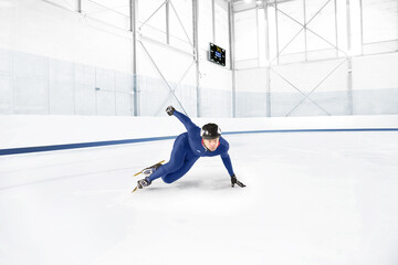 Young man practicing speed skating at ice rink