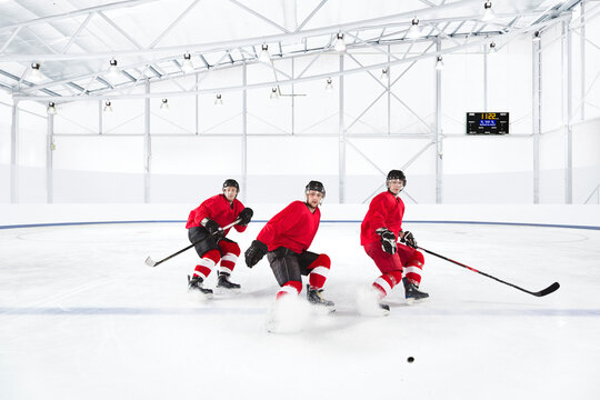 Ice hockey players skating in red uniforms