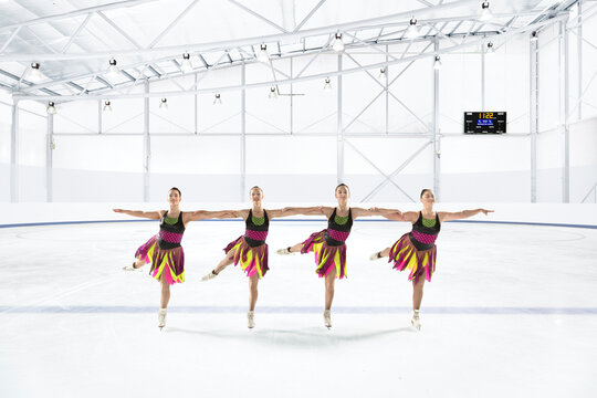 Team of synchronized skaters practicing at ice rink